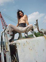 Eve Miller on an old excavator in light gray pantyhose without panties and skirt
